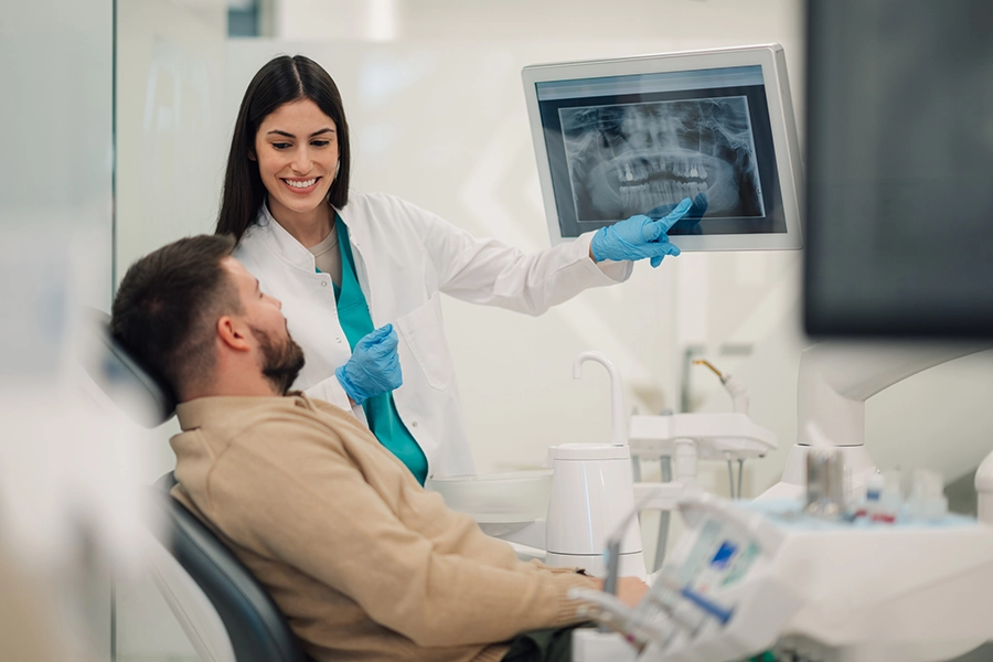 Dental professional discussing dental X-ray results with a patient